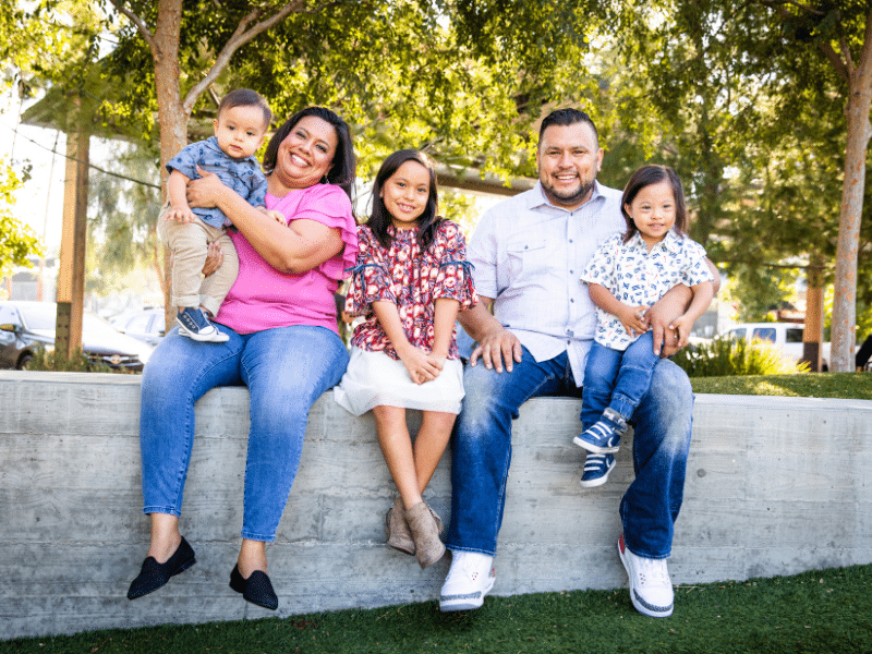 A family sitting outside smiling.