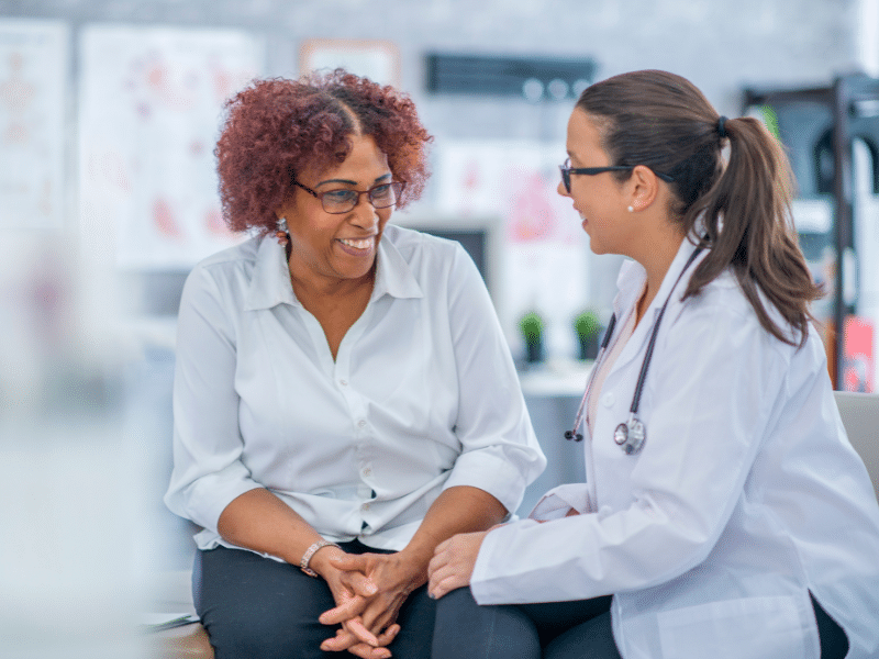 A woman smiling with her doctor.