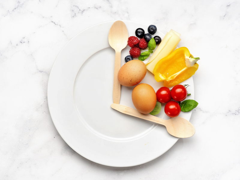 A plate arranged like a clock with healthy foods on it.