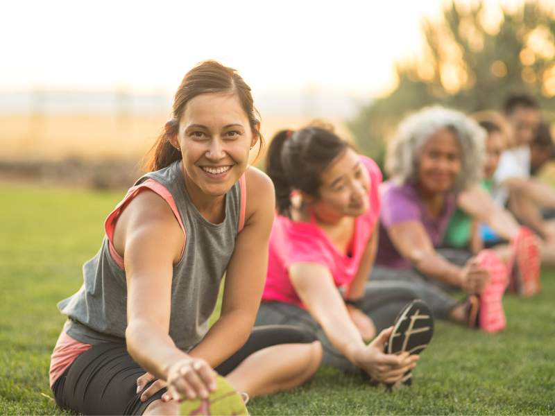 A group of women stretching outside.