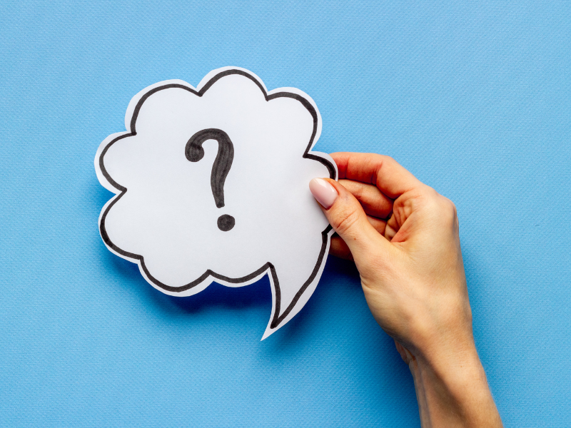 A hand holding a question mark.