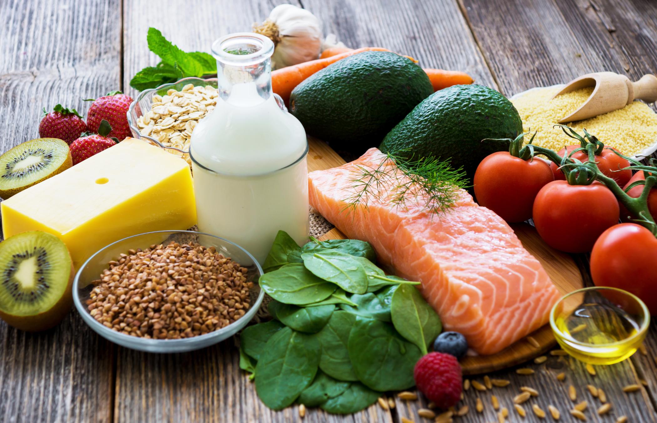 A spread of healthy foods including salmon and tomatoes.