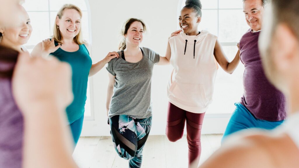 A diverse group of people exercising and smiling.