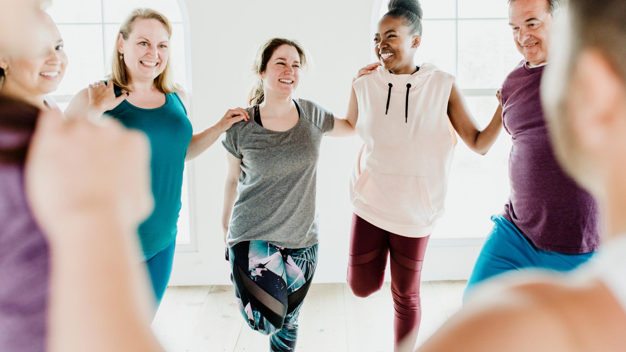 A diverse group of people exercising and smiling.