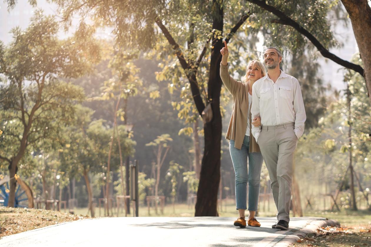 An older man and older woman walking outside.
